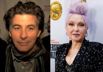 Cyndi Lauper attending an event, wearing a black sequined outfit with a distinctive hairstyle.