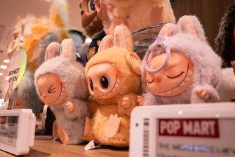 Plush collectible figures related to the Labubu character displayed at Pop Mart's exhibition.